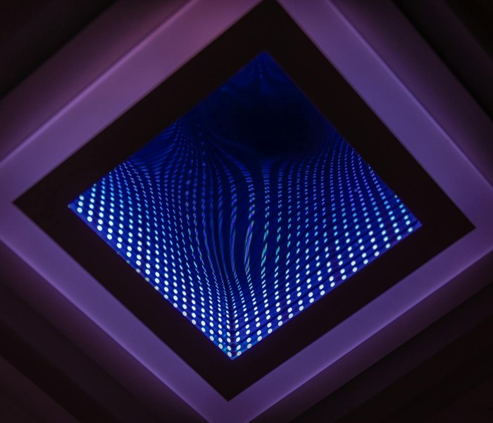 A captivating abstract view of a LED infinity mirror with vibrant light patterns.